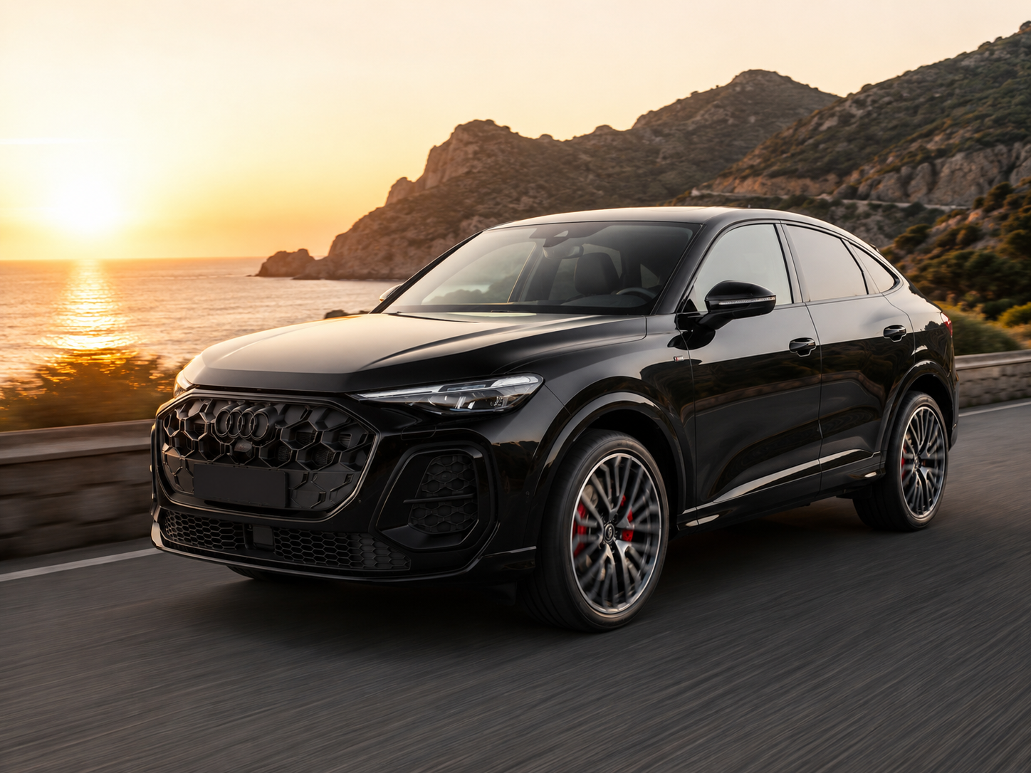 Audi Q5 Sportback Mythos Black in corsa sulla costa al tramonto